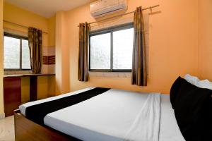 a bedroom with a white bed and a window at Hotel O Agarpara Railway Station Road Formerly Chowdhury Guest House in kolkata +22 photos