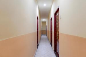 a corridor of a room with two doors at Hotel O Agarpara Railway Station Road Formerly Chowdhury Guest House in kolkata