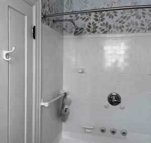 a white bathroom with a shower with a sink at Munroe Inn Boutique Hotel in Auburn