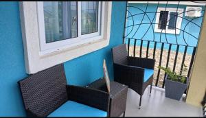 a balcony with two chairs and a glass window at The Chill Spot in Mo Bay in Crooked River