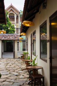 a patio with tables and chairs and a building at Tan Ca Home & Studio Ninh Bình in Kỳ Vĩ