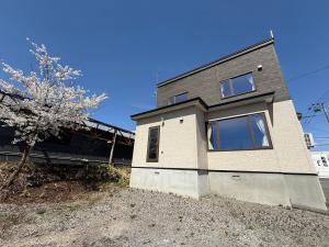 a house on a hill with a tree in front of it at Gold rich 2 in Asahikawa