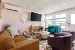 a living room with a couch and chairs and a tv at Timberline Flats in Traverse City