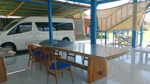 a table and two chairs and a white van at Blue Rose Resort & Dive Center in Pattimura Airport