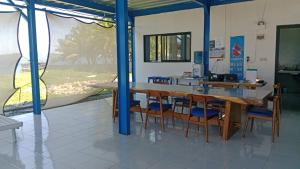 a dining room with a wooden table and chairs at Blue Rose Resort & Dive Center in Pattimura Airport