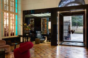a lobby with a red chair and a mirror at Grand Hotel Palace Rome in Rome