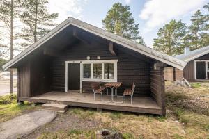 a cabin with a table and chairs on a deck at Bruna Byn in Sälen