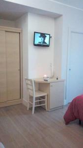 een kamer met een bureau en een tv aan de muur bij B&B Valle Gio' in Magliano deʼ Marsi