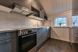 a kitchen with a stove and a sink at Bruna Byn in Sälen