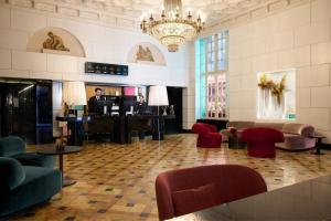 a lobby with a grand piano and red chairs at Grand Hotel Palace Rome in Rome