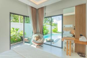 a bedroom with a bed and a living room with a pool at Luxury B Baya Pool Villa in Ban Chong Phli +28 photos