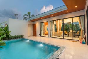 a house with a swimming pool in front of it at Luxury B Baya Pool Villa in Ban Chong Phli