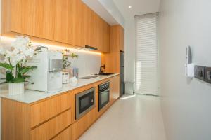 a kitchen with wooden cabinets and a counter top at Luxury B Baya Pool Villa in Ban Chong Phli