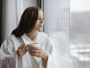 a woman in a bathrobe holding a cup of coffee at Mercure Stuttgart Zuffenhausen in Stuttgart +39 photos