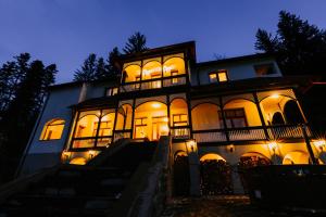 a large building with lit up windows at night at Lucy Villa in Băile Tuşnad