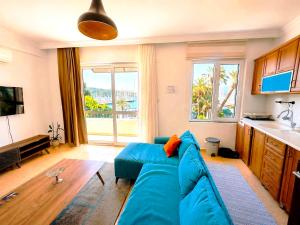 a living room with a blue couch and a large window at BlueTown Fethiye in Fethiye