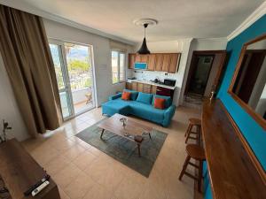 a living room with a blue couch and a table at BlueTown Fethiye in Fethiye