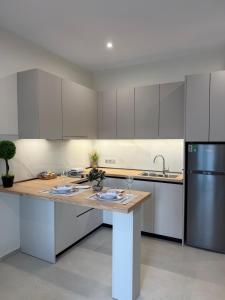 a kitchen with white cabinets and a wooden counter top at Olympus Hospitality Rhodes in Rhodes Town