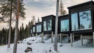a house in the woods in the snow at Arctic Panorama Resort in Rovaniemi