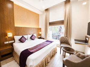 a hotel room with a large bed and a window at Hotel Hari Piorko - New Delhi Railway Station in New Delhi