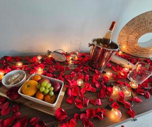 a table with red roses and a bottle of wine and fruit at Ocean's Heaven in Ensenada