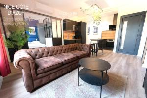 a living room with a brown couch and a table at Loft climatisé - proche de la mer - jacuzzi - Nice centre in Nice
