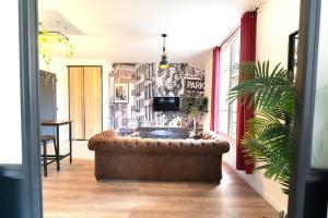 a living room with a couch in front of a wall at Loft climatisé - proche de la mer - jacuzzi - Nice centre in Nice