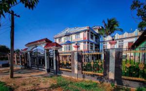 a large house with a fence in front of it at Madhuban Resort in Silchar