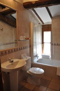 a bathroom with a toilet and a sink and a tub at La Cuculla in Ezcaray