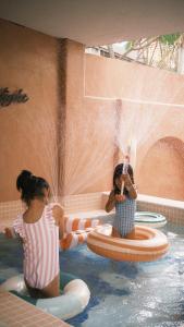 two girls playing in the water in a swimming pool at 夏漾旅店Summer Delight 包棟民宿 in Nanwan