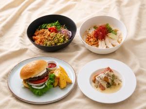 a table with three plates of food and bowls of food at Tokyu Stay Sapporo in Sapporo