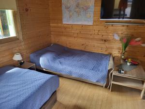 a bedroom with two beds in a wooden room at Aiamaja Sindi Location Sindi Kirsi 3 in Pärnu