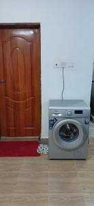 a washing machine sitting in front of a door at Sunny Studio Kikuyu Town in Kikuyu