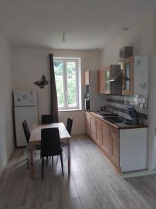 a kitchen with a wooden table and a table and chairs at Gîte Le 500 in Mayres