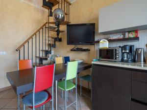 a kitchen with a table with chairs and a tv at Snug Holiday Home in Lazise with Heating, near Lake Garda in Lazise