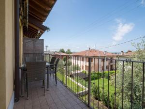 a patio with a table and chairs on a balcony at Snug Holiday Home in Lazise with Heating, near Lake Garda in Lazise