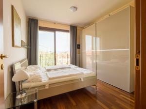 a bedroom with a bed and a large window at Snug Holiday Home in Lazise with Heating, near Lake Garda in Lazise