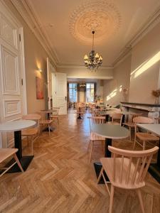 a restaurant with tables and chairs and a chandelier at Parkhotel Gent Centrum in Ghent +76 photos
