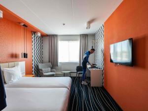 a man standing at a counter in a hotel room at ibis Styles Haarlem City in Haarlem