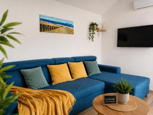 a blue couch in a living room with a table at Seaside Cottage Barbariga in Peroj
