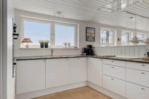 a white kitchen with white cabinets and windows at OH451-Hadsund-Haslevgaarde-Bakker-72 in Hadsund +13 photos