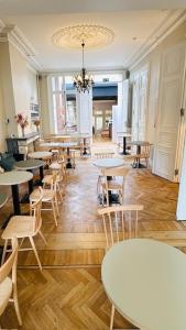 a room with tables and chairs and a chandelier at Parkhotel Gent Centrum in Ghent