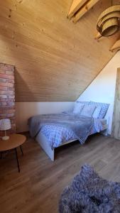 a bedroom with a bed and a wooden ceiling at Bliżej Lasu - Rodzinny domek w górach in Stary Gieraltów