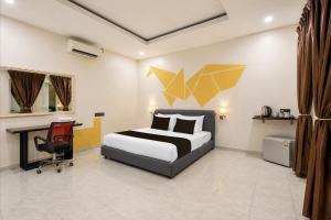 a bedroom with a bed and a desk and a chair at Collection O Langkawi Near Pantai Cenang formerly Tokman Inn in Pantai Cenang
