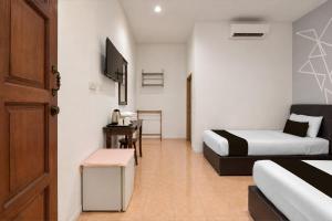 a hotel room with two beds and a desk at Collection O Langkawi Near Pantai Cenang formerly Tokman Inn in Pantai Cenang +43 photos