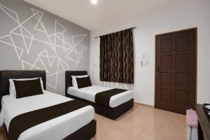 a hotel room with two beds and a window at Collection O Langkawi Near Pantai Cenang formerly Tokman Inn in Pantai Cenang