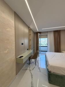 a hotel room with a bed and a desk at Merxhan`S Apartment in Golem