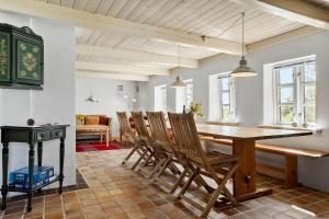 a dining room with a wooden table and chairs at LF10211-Thyholm-Ronbakken-11 in Thyholm +15 photos