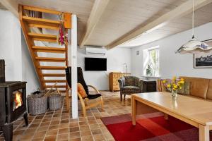 a living room with a table and a wood stove at LF10211-Thyholm-Ronbakken-11 in Thyholm