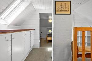 an attic room with a white wall with a picture of a boat at LF10211-Thyholm-Ronbakken-11 in Thyholm